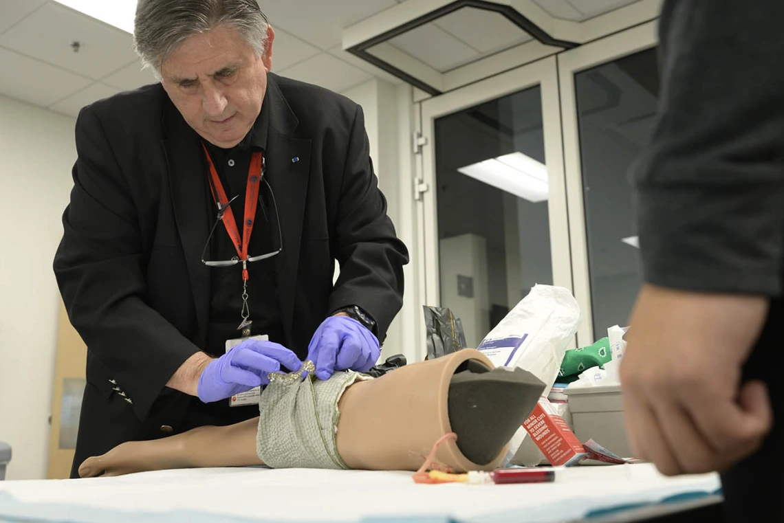 The director of the Arizona Simulation Technology and Education Center, demonstrates a field dressing for Doctor of Nursing Practice students.