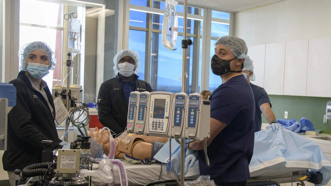 Certified Registered Nurse Anesthetists students watch the monitors in the Arizona Simulation Technology and Education Center after administering medication to a manikin during a simulation.