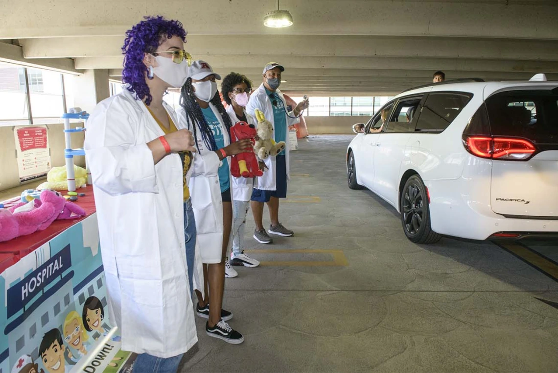 Students from the College of Medicine – Phoenix visit with kids as their parents slowly drove by the Wildcat Play Hospital, run by the Black African American Caribbean Employee Resource Group.