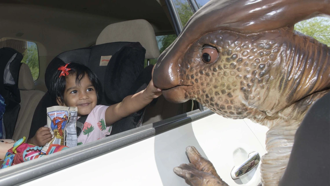 A costumed dinosaur character brought science to life for visitors attending an innovative drive-through Connect2STEM event in Phoenix on Saturday, May 22, 2021. 