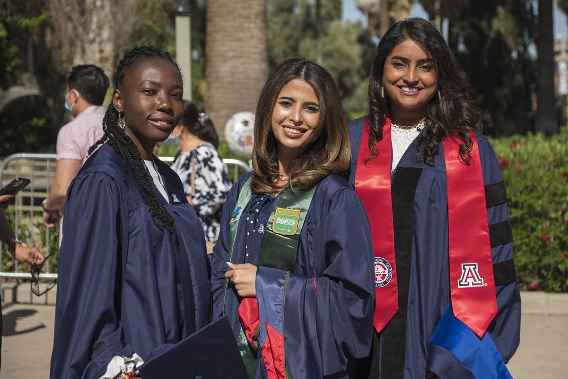 (From left) Mavis Obeng-Kusi, MSPS, Nouf Bin Awad, MSPS, and Srujitha Marupuru, PhD, pose for a photo before the start of the R. Ken Coit College of Pharmacy 2022 spring convocation at Centennial Hall.