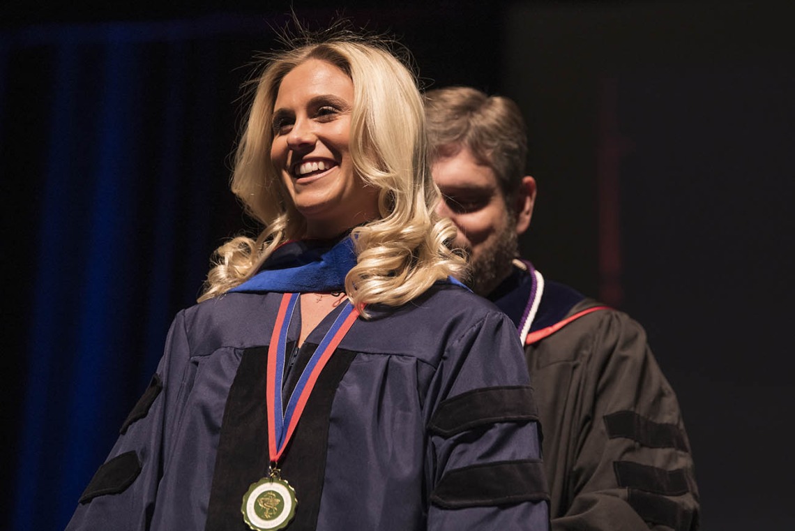 Kayla Frost, PhD, is hooded by Nathan Cherrington, PhD, ATS, for earning a Doctor of Philosophy degree in pharmacology and toxicology during the R. Ken Coit College of Pharmacy 2022 spring convocation at Centennial Hall.
