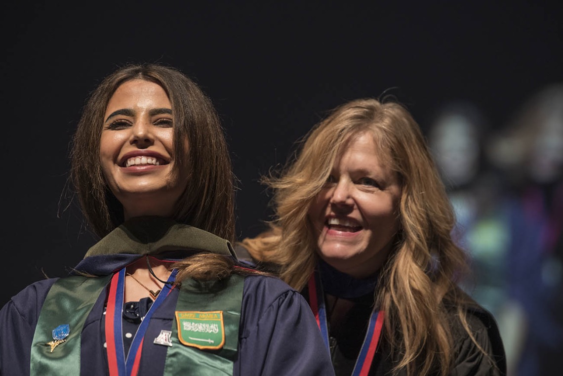 Nouf Bin Awad, MSPS, smiles after being hooded by Terri Warholak, PhD, RPh, for earning her Master of Science in Pharmaceutical Sciences during the R. Ken Coit College of Pharmacy 2022 spring convocation at Centennial Hall.