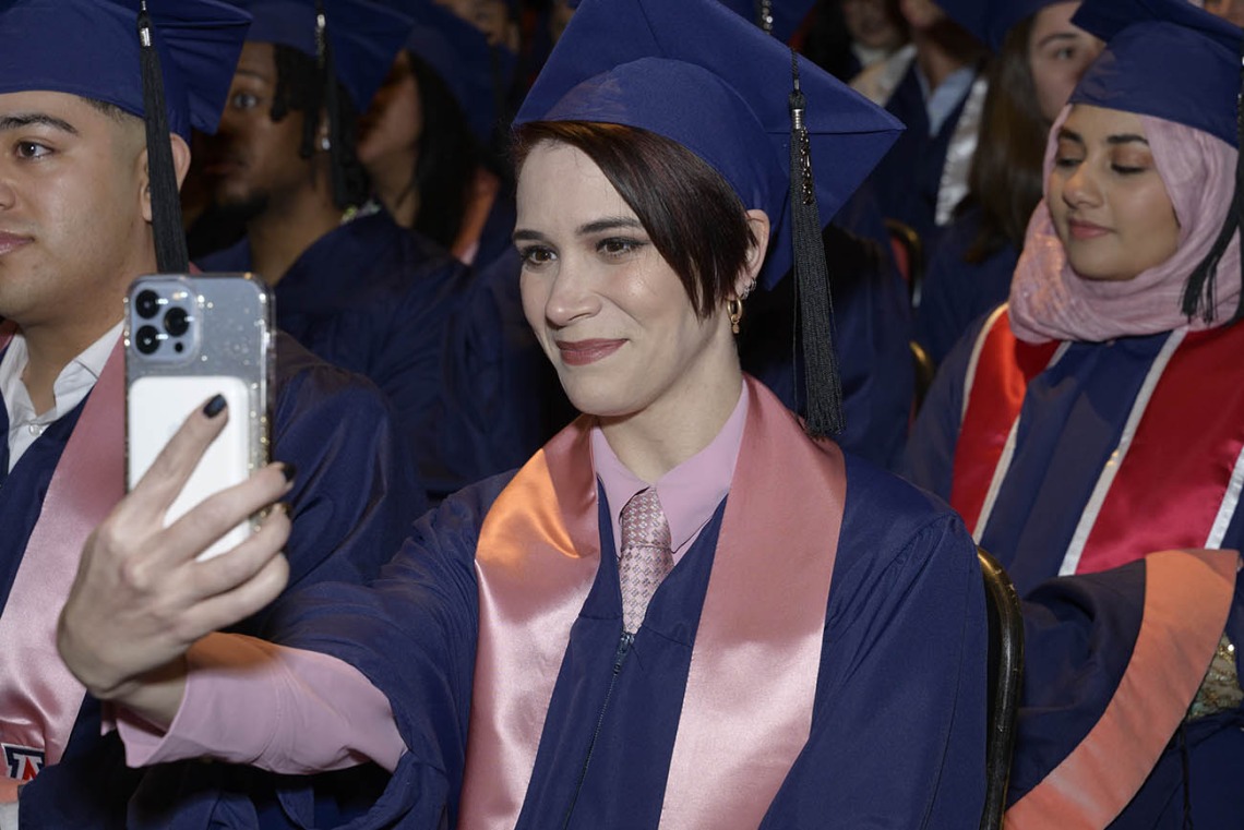 Iris Elizabeth Lococo, who graduated with a Master of Public Health degree, snaps a photo during the Mel and Enid Zuckerman College of Public Health fall convocation.