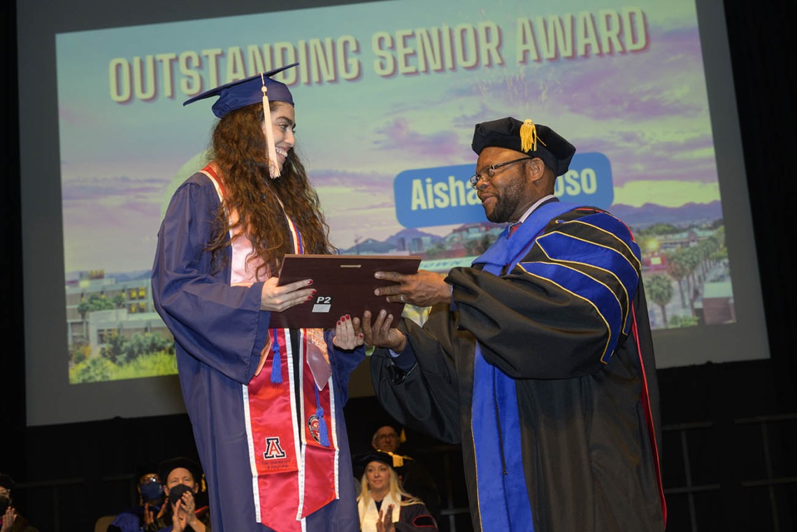 Aisha Fregoso is presented with the Outstanding Senior Award by John Ehiri, PhD, MPH, MSc, during the Mel and Enid Zuckerman College of Public Health fall convocation. 