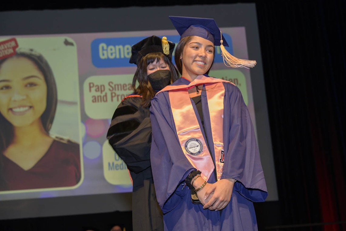 Master of Public Health graduate Geneva Frank is hooded by associate professor Nicole Yuan, PhD, MPH, during the Mel and Enid Zuckerman College of Public Health fall convocation.