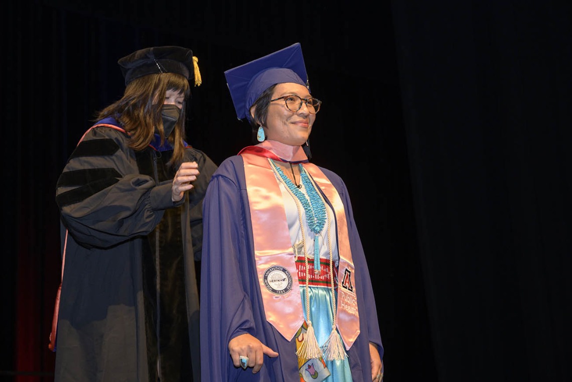 Master of Public Health graduate Breanna Lameman is hooded by associate professor Nicole Yuan, PhD, MPH, during the Mel and Enid Zuckerman College of Public Health fall convocation. 
