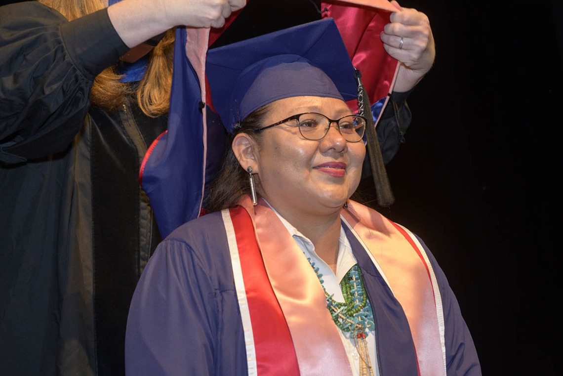 Lucynda Gorman Dahozy prepares to be hooded as a Master of Public Health graduate during the Mel and Enid Zuckerman College of Public Health fall convocation.