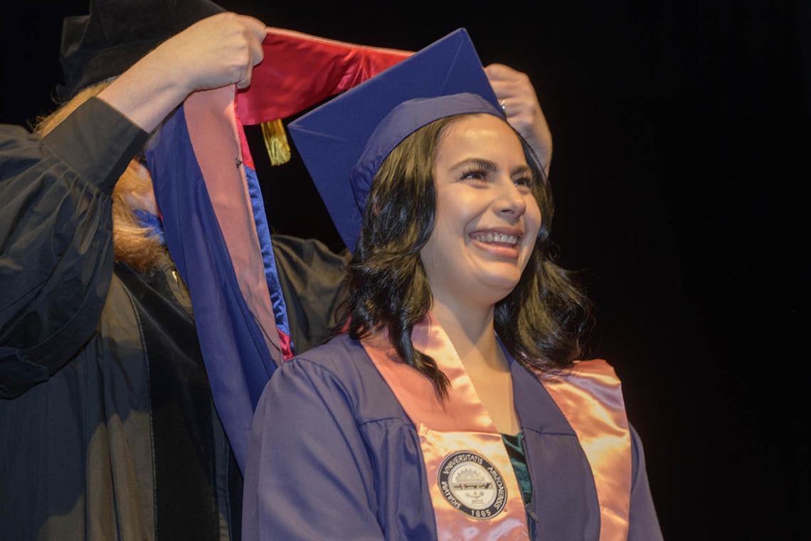 Belen Alejandra Mejia happily anticipates being hooded as a Master of Public Health graduate during the Mel and Enid Zuckerman College of Public Health fall convocation.