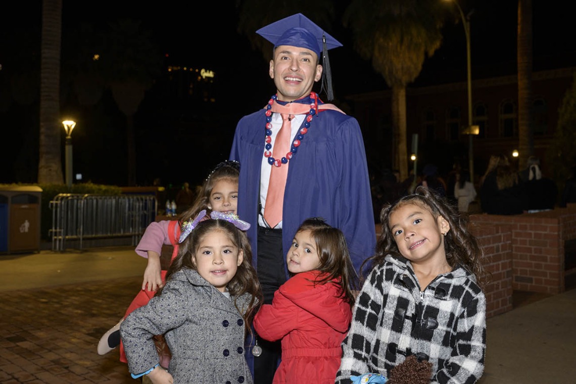 Master of Public Health graduate Eduardo Estrada is congratulated by his daughters and nieces the Mel and Enid Zuckerman College of Public Health fall convocation.