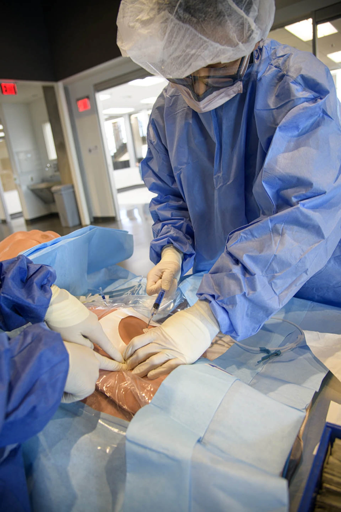 ASTEC’s SimDeck is a two-story soundstage and training environment with multiple reconfigurable rooms where health care providers, such as these critical care residents, can practice medical procedures in simulated environments.