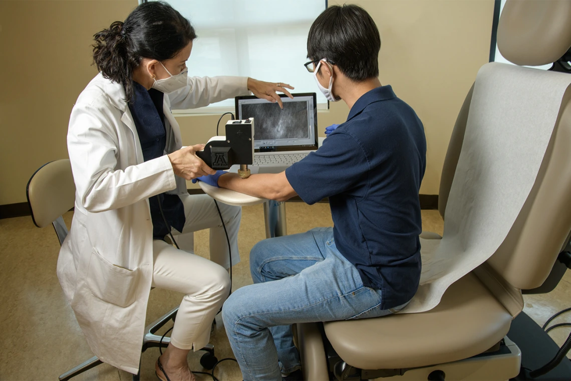 Drs. Curiel and Kang look at the image quality of the handheld skin cancer diagnostic microscope they are developing. The technology is meant to provide a less expensive, portable version of a machine that is presently cost-prohibitive for many medical facilities.