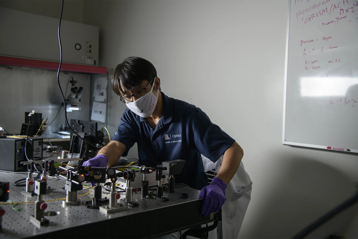 Dongkyun Kang, PhD, works to align the laser optics to increase the light power of a portable confocal microscope he is  developing with Clara Curiel-Lewandrowski, MD.