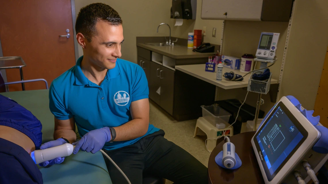Edgar A. Villavicencio does a FibroScan test on a Nosotros Comprometidos a Su Salud (Committed to Your Health) study participant.
