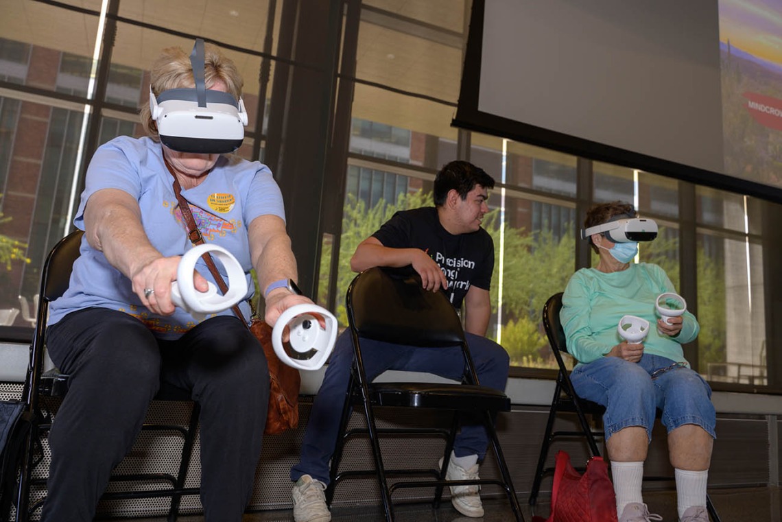 Attendees practice virtual reality tai chi while wearing VR headsets and holding touch controllers during the Feast for Your Brain community event on Sept. 10.