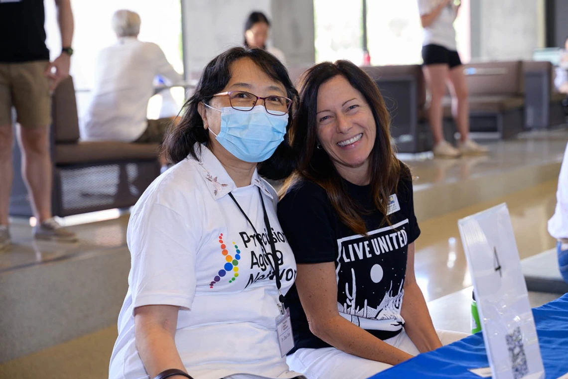 (From left) Zhao Chen, PhD, MPH, professor and associate dean for research in the Mel and Enid Zuckerman College of Public Health, and Elizabeth Cozzi, associate vice president of community development at the United Way of Tucson, pause for a moment at the Feast for Your Brain event.