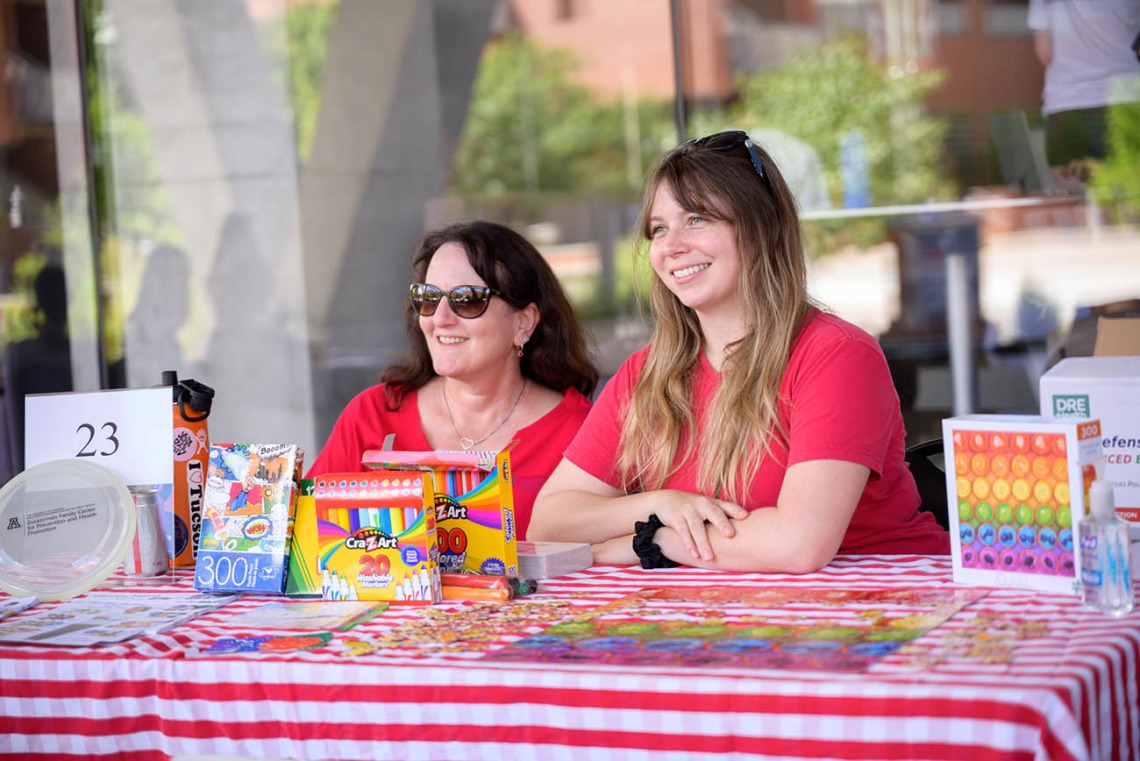 (From left) Sabrina Plattner, MEd, and Lindsay Bingham, MPH, CHES, both senior health educators in the Mel and Enid Zuckerman College of Public Health, volunteer at an activity table during the inaugural Feast for Your Brain community event on Sept. 10.