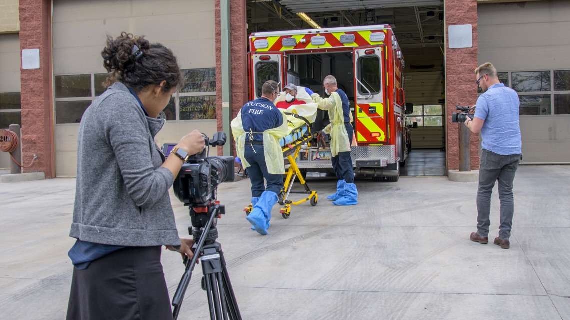 University of Arizona Health Sciences’ Viola Watson (left) and Erich Healy (right) wield cameras as the Tucson Fire Department, in partnership with the College of Public Health, produces a training video to help first responders prevent disease transmission.