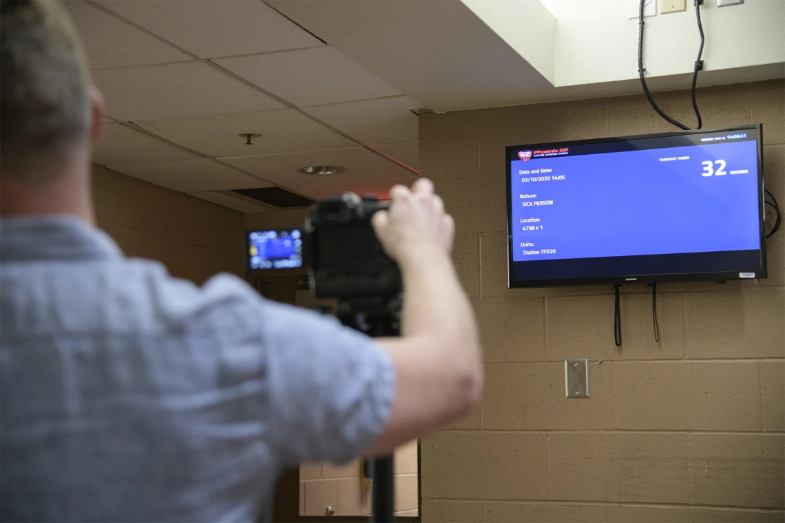 Erich Healy films an incoming call at the fire station during the training exercise. Healy works for the Mel and Enid Zuckerman College of Public Health and the Western Regional Public Health Training Center.