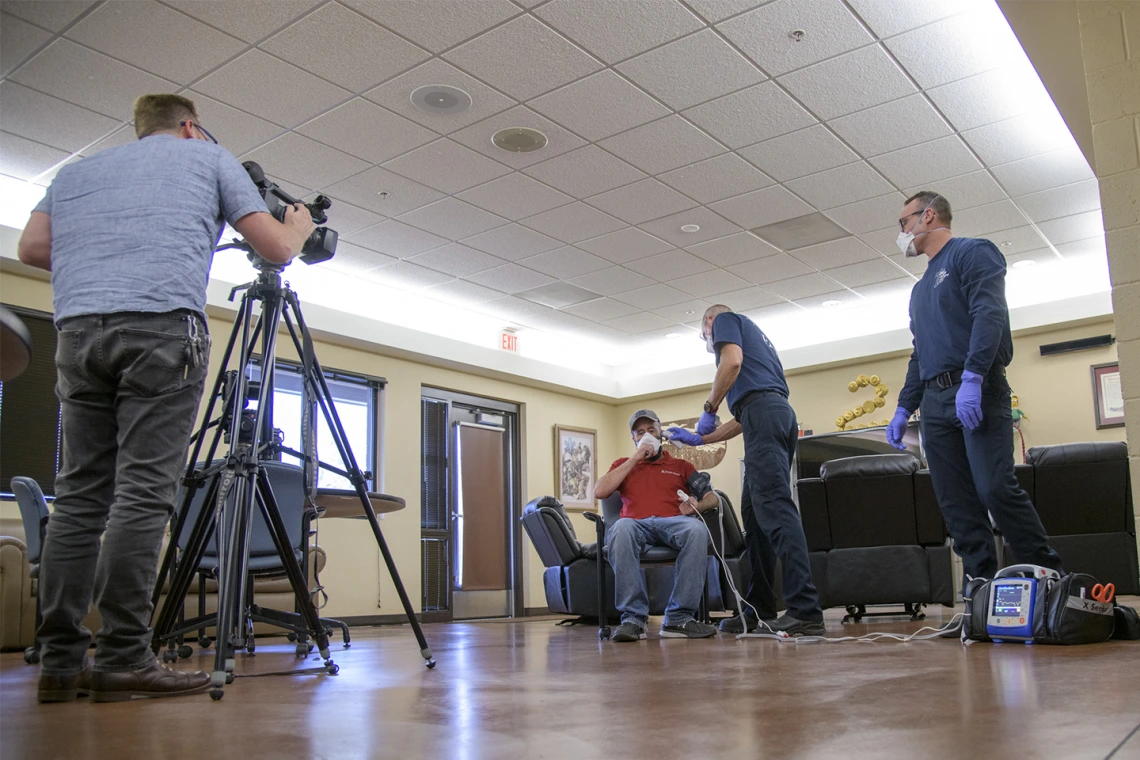 Erich Healy films the interaction of Tucson Fire Department’s Chris LaFave and Taylor Parrish with Jonathan Sexton, PhD, who is playing the role of a patient in a training video on infection control. Healy works for the Mel and Enid Zuckerman College of Public Health and the Western Regional Public Health Training Center.