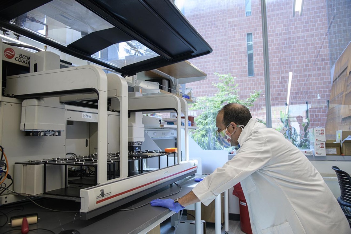 Matthew Kaplan, manager for University of Arizona Functional Genomics Core, evaluates the Biomek robot prior to performing antibody testing.