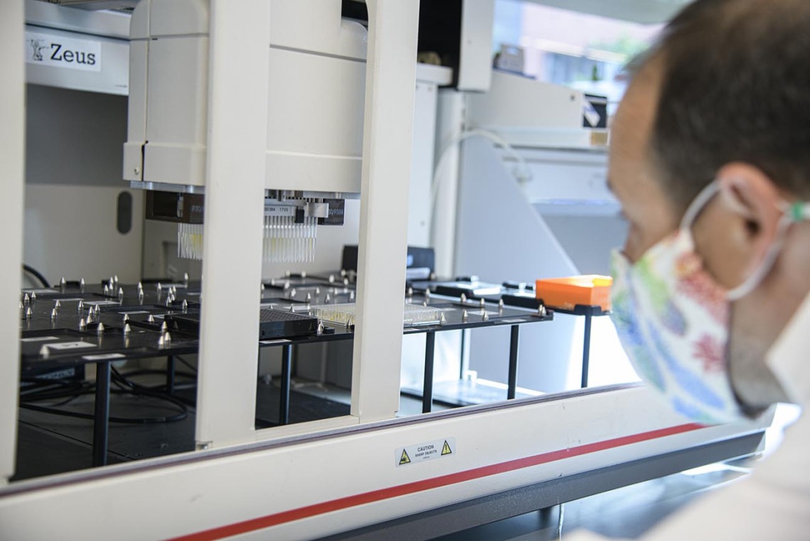Matthew Kaplan, manager for University of Arizona Functional Genomics Core, evaluates the Biomek robot prior to performing antibody testing.