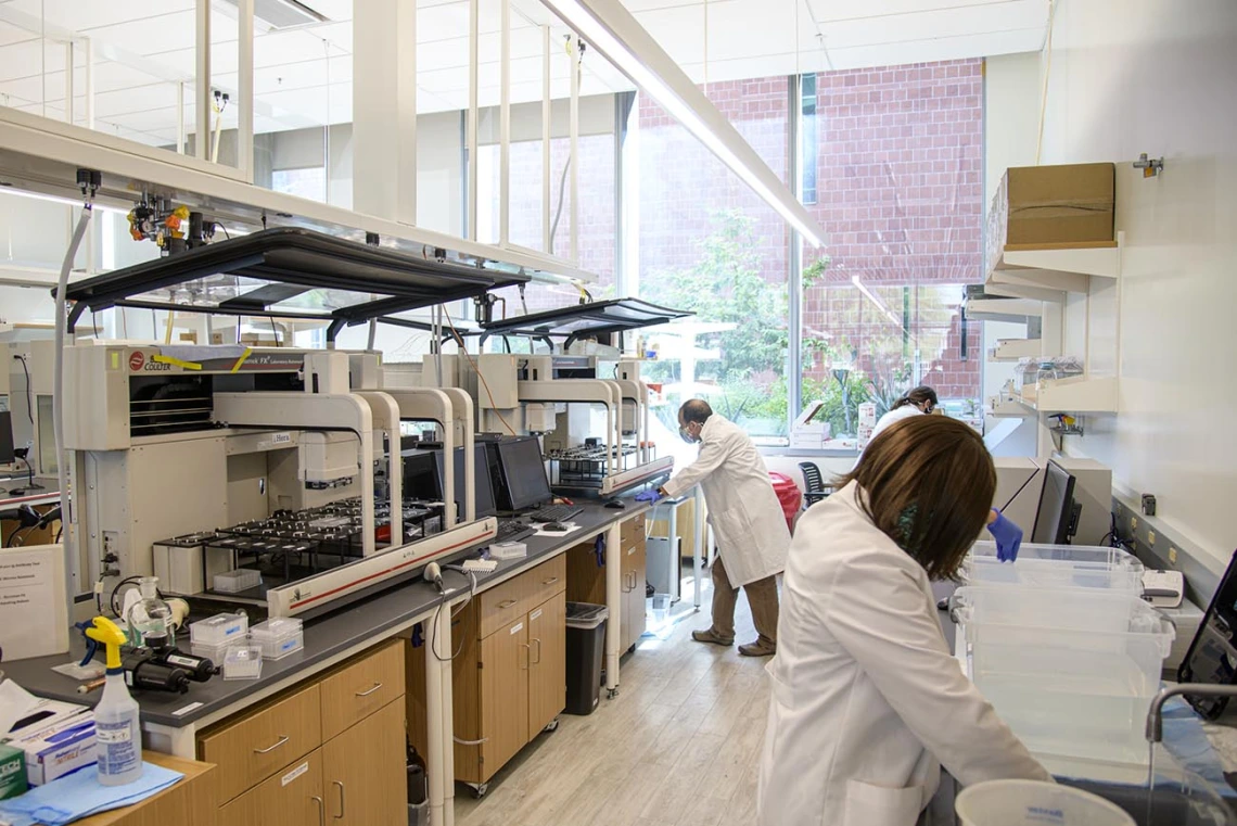 Lab workers prepare washes and buffers for the robotic test.