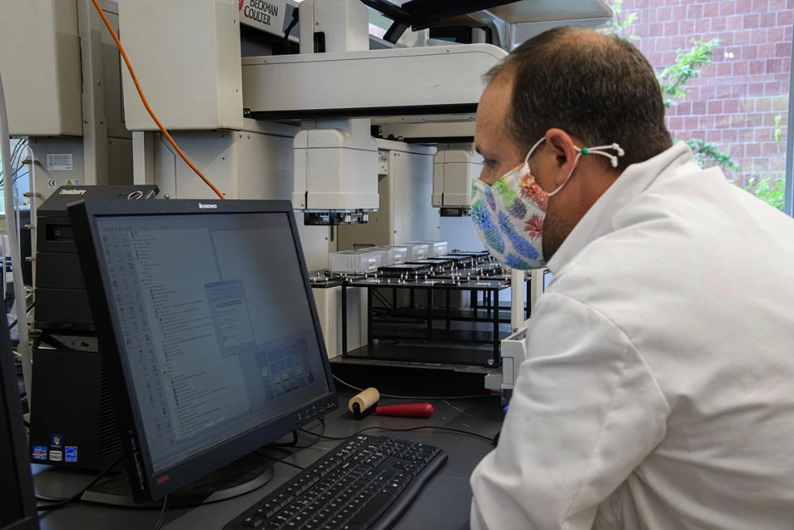 Matthew Kaplan, manager of University of Arizona Functional Genomics Core, makes some adjustments during the evaluation of the Biomek robot prior to testing blood samples for antibodies to the virus that causes COVID-19. 