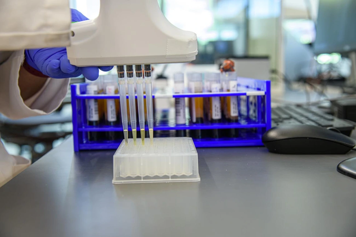 Barbara Fransway, manager of University of Arizona Genetics Core Research Services, transfers blood serum into testing plates.