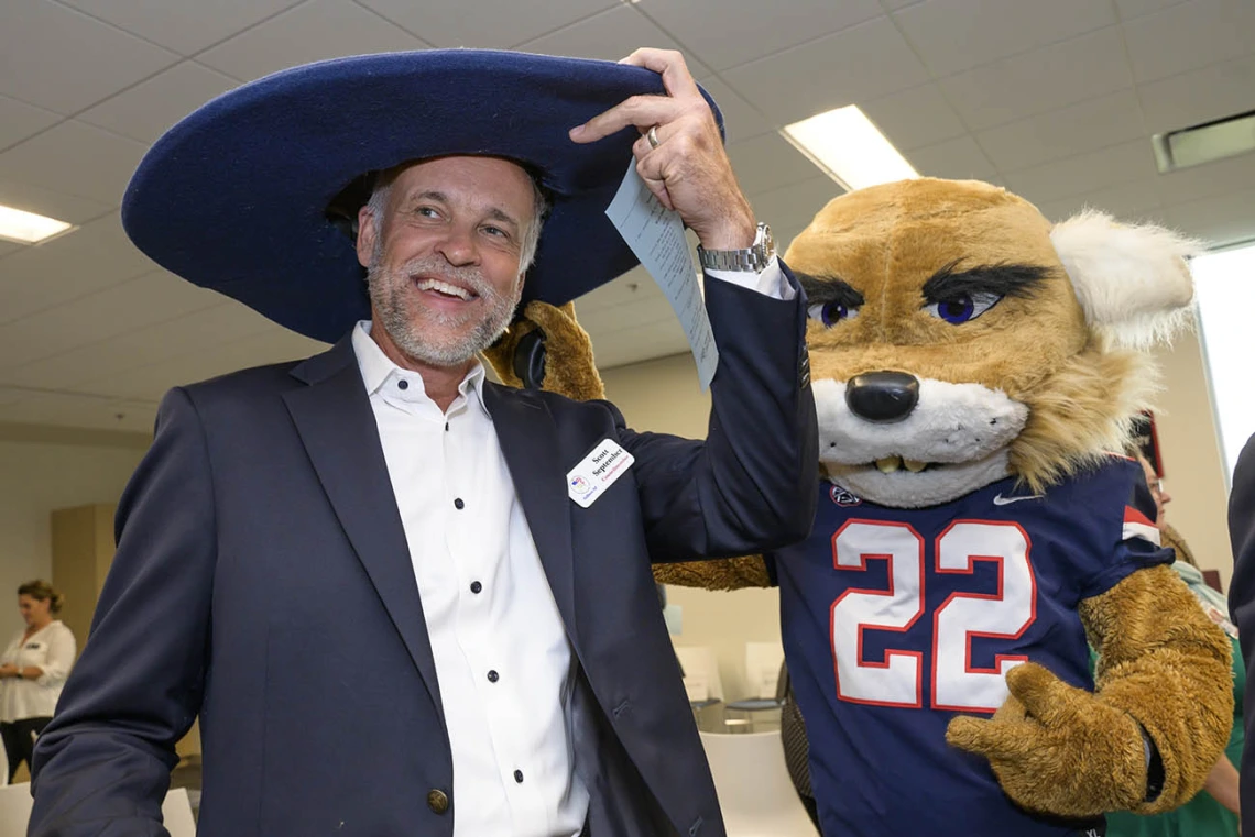 Gilbert, Arizona, town council member Scott September tries on Wilbur Wildcat’s hat during the ribbon-cutting event at the UArizona College of Nursing’s renovated facility. 