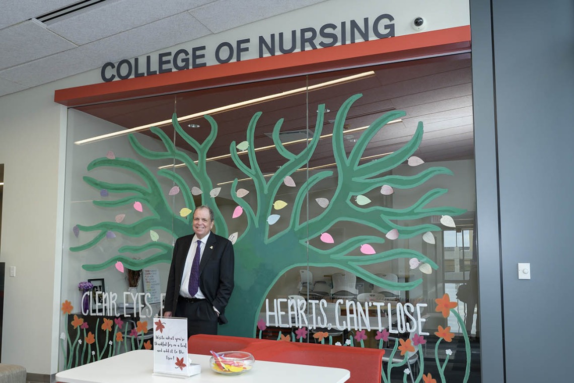 UArizona Health Sciences Senior Vice President Michael D. Dake, MD, stands at the entrance of the College of Nursing’s renovated third-floor facility in Gilbert, Arizona.