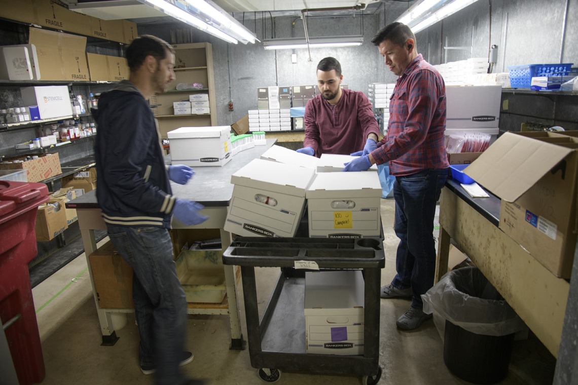Biorepository laboratory technicians Brandon Jernigan, Ayman Sami, and Jose Camarena, load boxes of COVID-19 sample collection kits to deliver to Banner-University Medical Center Tucson.