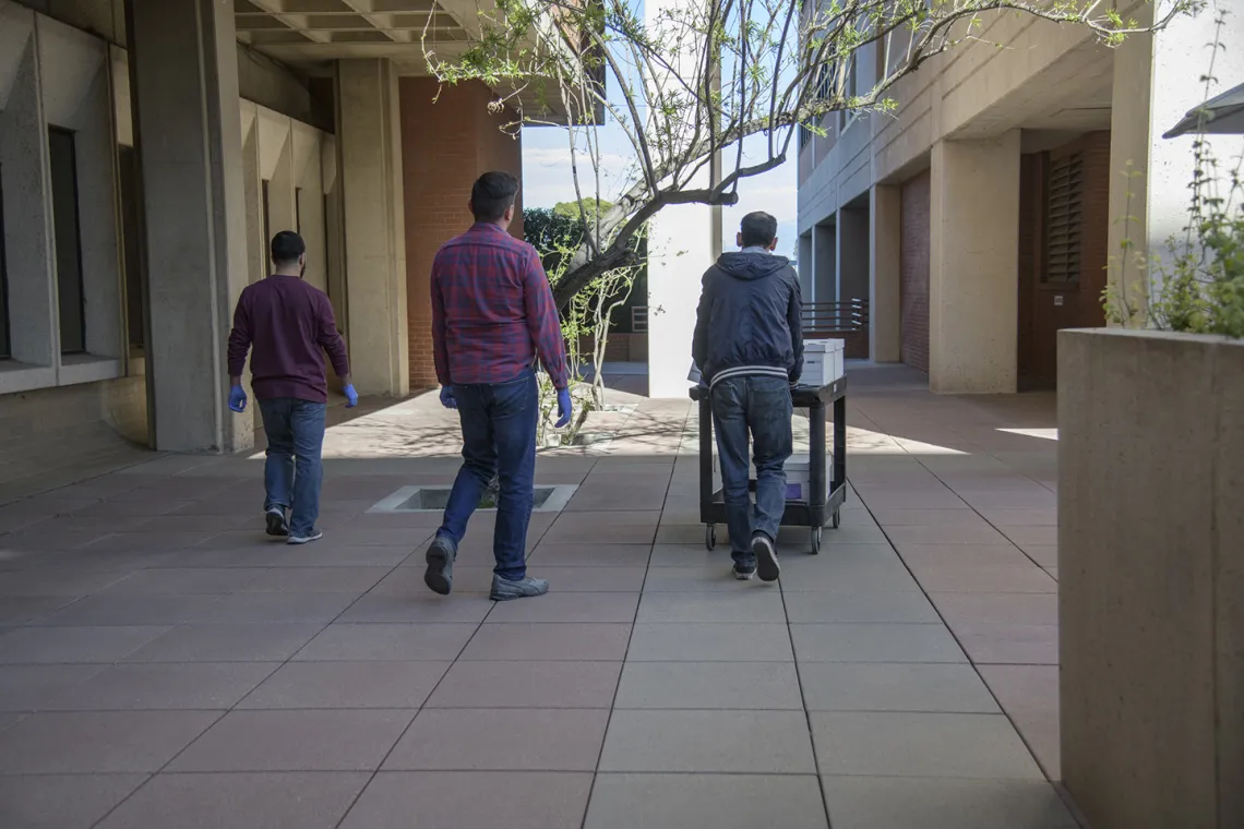 Lab Techs stand by before loading the kits into a Banner van as local media prepares to film.