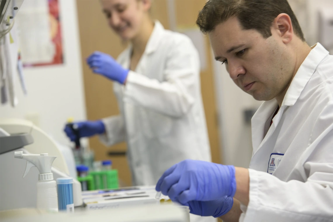 Postdoctoral fellow Jason Maarsingh, PhD (foreground), and undergraduate Mary Salliss work to find the link between the vaginal microbiome and gynecologic cancer.