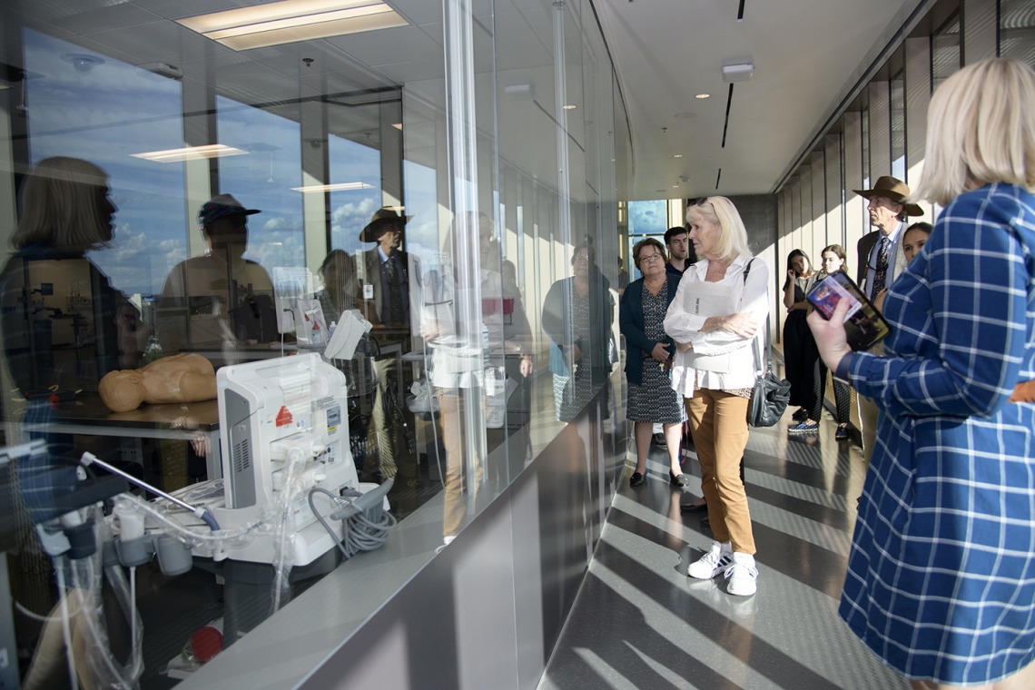 Faculty peer into the “aquarium” windows of the Arizona Simulation Technology and Education Center, or ASTEC.