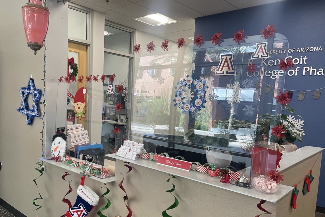 The R. Ken Coit College of Pharmacy Office of Student Services reception area is filled with holiday decorations. 