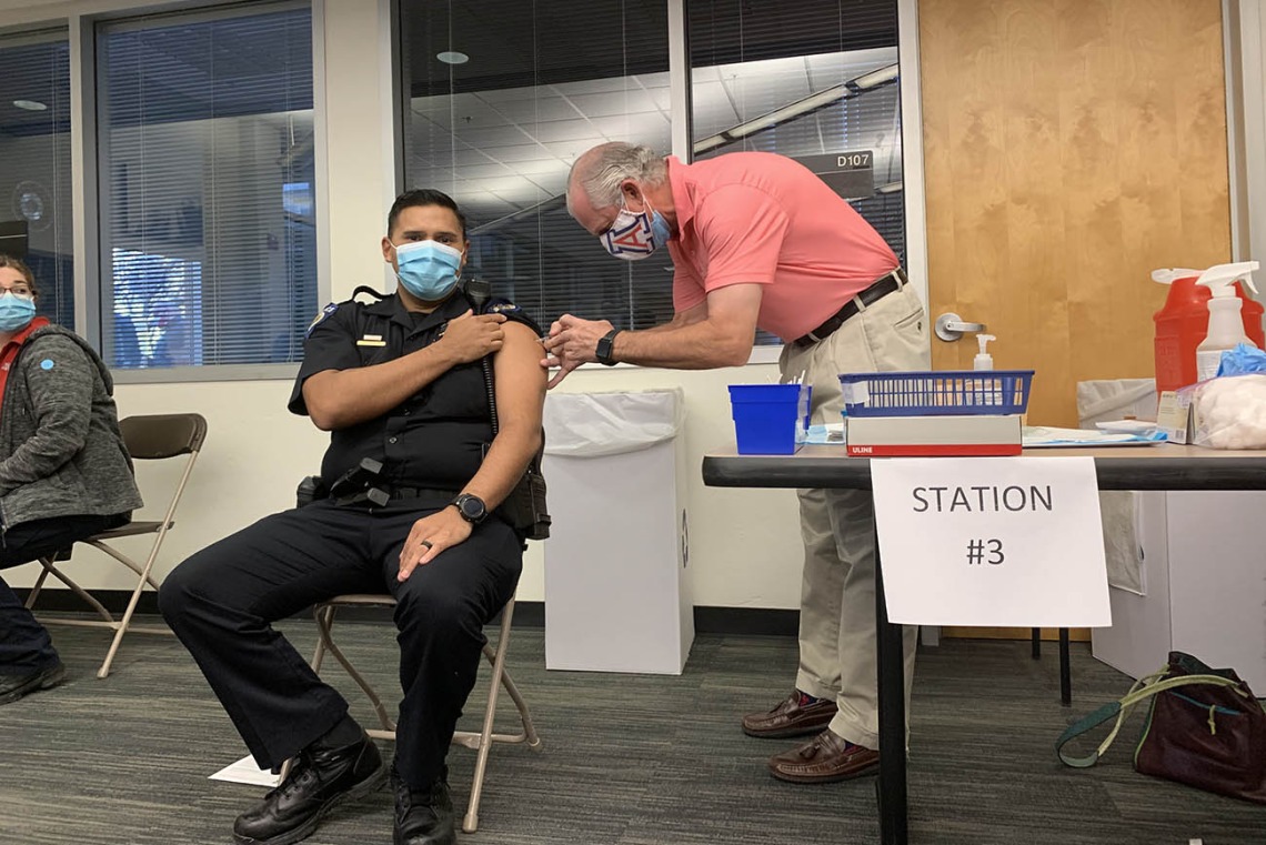 University of Arizona President Robert C. Robbins, MD, administers the vaccine to a University of Arizona Police officer.
