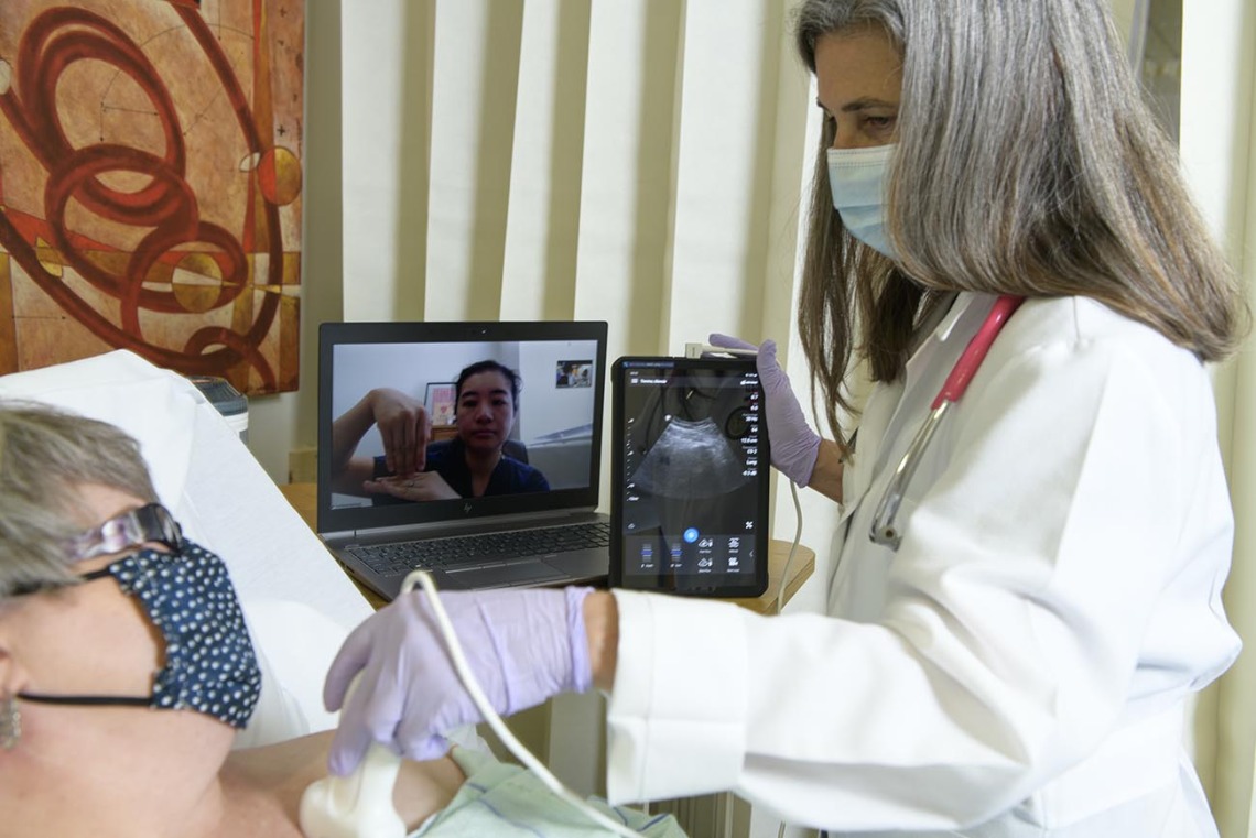 Dr. Elaine Situ-LaCasse (pictured on the laptop) receives a livestream of the exam results and assists in diagnosing a standardized patient during a telehealth training consultation with Julia Brown, MD, emergency department medical director at the Copper Queen Community Hospital in Bisbee, Arizona.