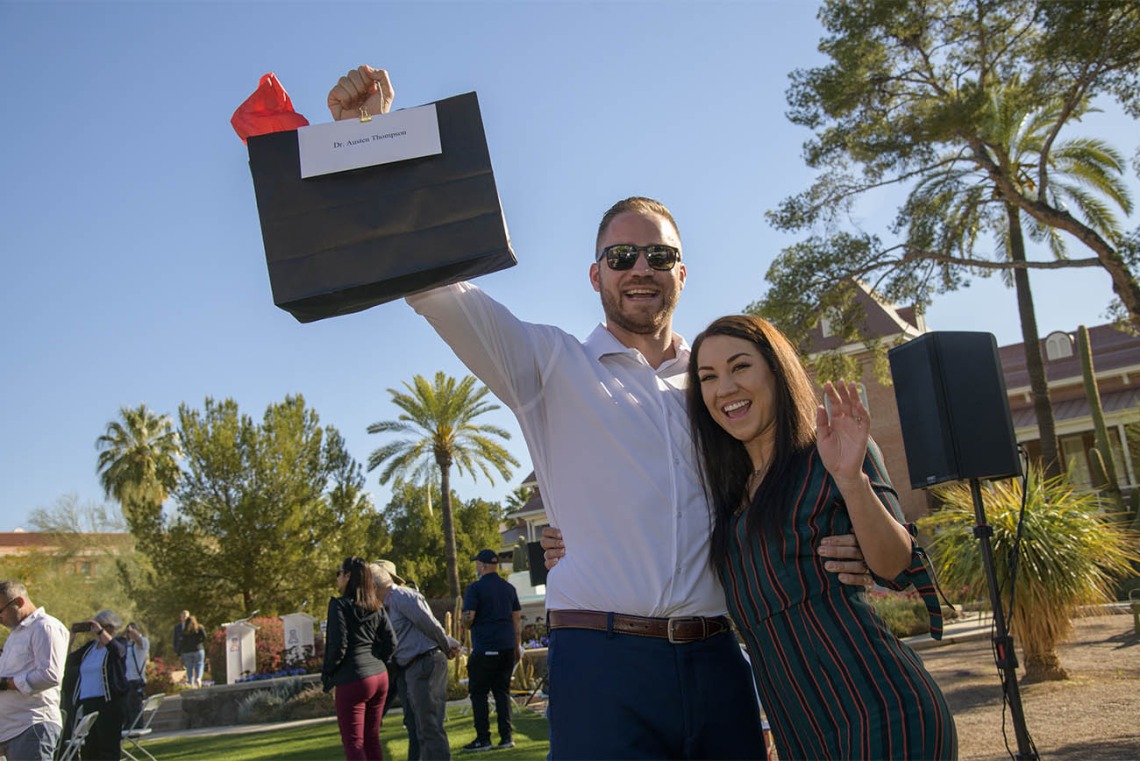 Austen and Darian Thompson lift the bag that will tell them where they will be for the next four years before the 9 a.m. start to matching during the UArizona College of Medicine – Tucson 2022 Match Day event.