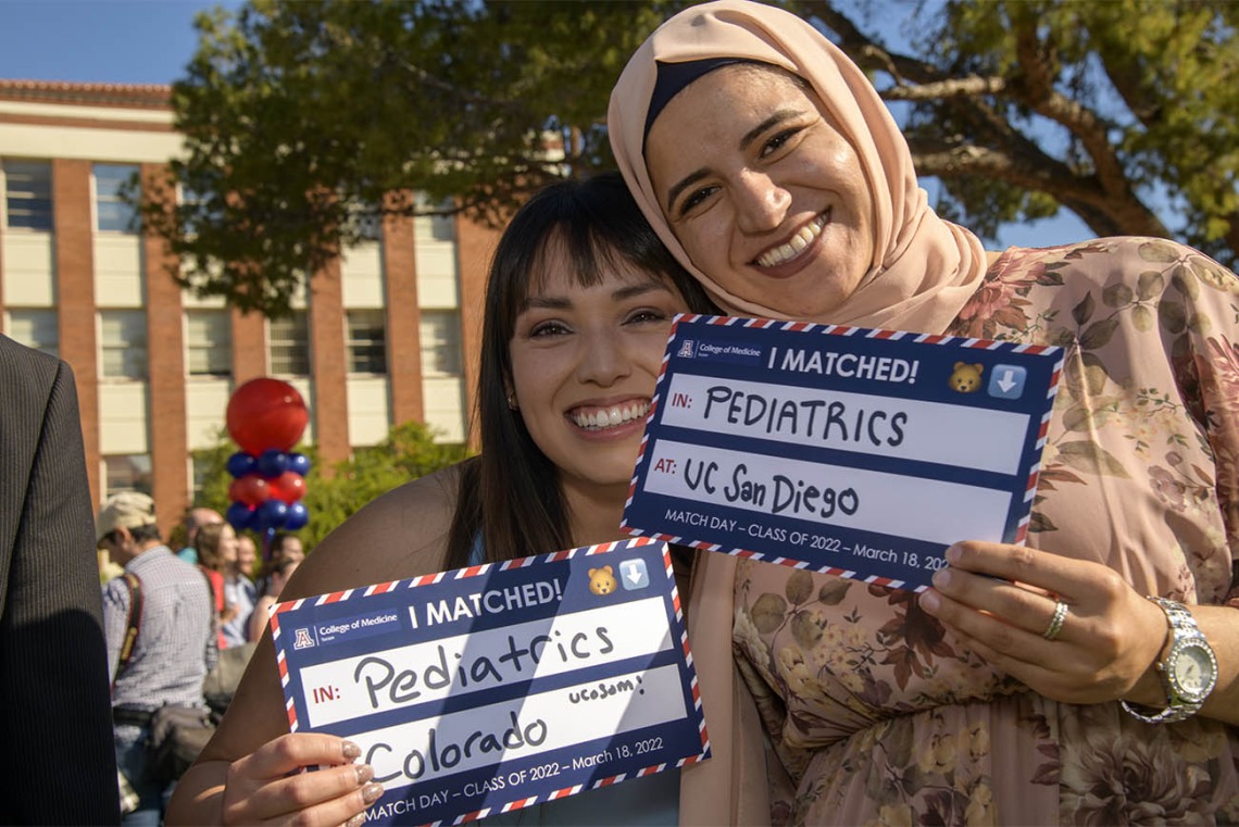 Paulina Ramos (left) and Tesneem Tamimi display their signs showing where they matched during the UArizona College of Medicine – Tucson 2022 Match Day event.