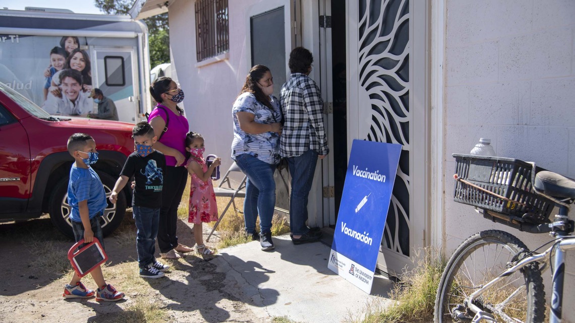People gather outside a community center for a MOVE-UP clinic hosted by UArizona Health Sciences in the rural town of Aguila, Arizona, to get COVID-19 vaccine shots.