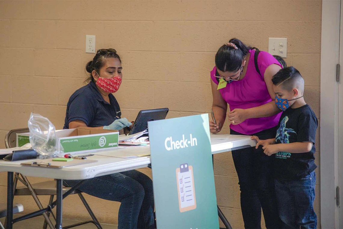 Alma Ramirez, a health educator with the College of Public Health, greets people at the community center in Aguila, Arizona, where UArizona Health Sciences provided free COVID-19 vaccinations. 