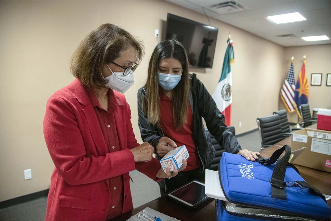 Cecilia Rosales, MD, and Sheila Soto, MPH, director and manager of the Tucson mobile health unit at the UArizona Mel and Enid Zuckerman College of Public Health, review packaging for the COVID-19 vaccines to be administered at a clinic hosted April 23 at the Mexican Consulate in Douglas, Ariz. Initially for farmworkers crossing over from Mexico starting at 3 a.m., the clinic was open to the public from 7 to 11 a.m.