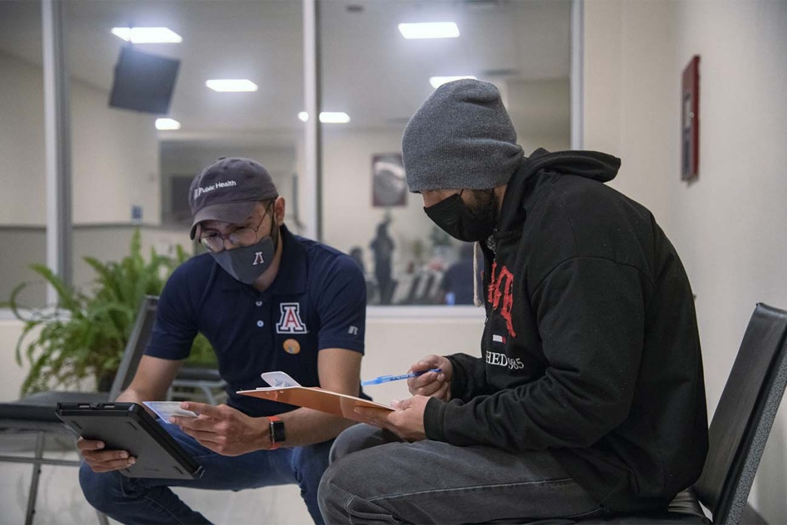 Zuckerman College of Public Health student José Angel Almeida (left) helps Oscar Moreno with his initial intake for registration at a COVID-19 vaccine clinic hosted April 23 by UArizona Health Sciences at the Consulate of Mexico in Douglas, Arizona.