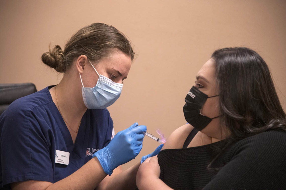 College of Nursing student Valerie Pedersen gives a woman a COVID-19 vaccine at a MOVE UP clinic at the Consulate of Mexico in Douglas hosted by the UArizona Health Sciences in partnership with the Cochise County Health Department.