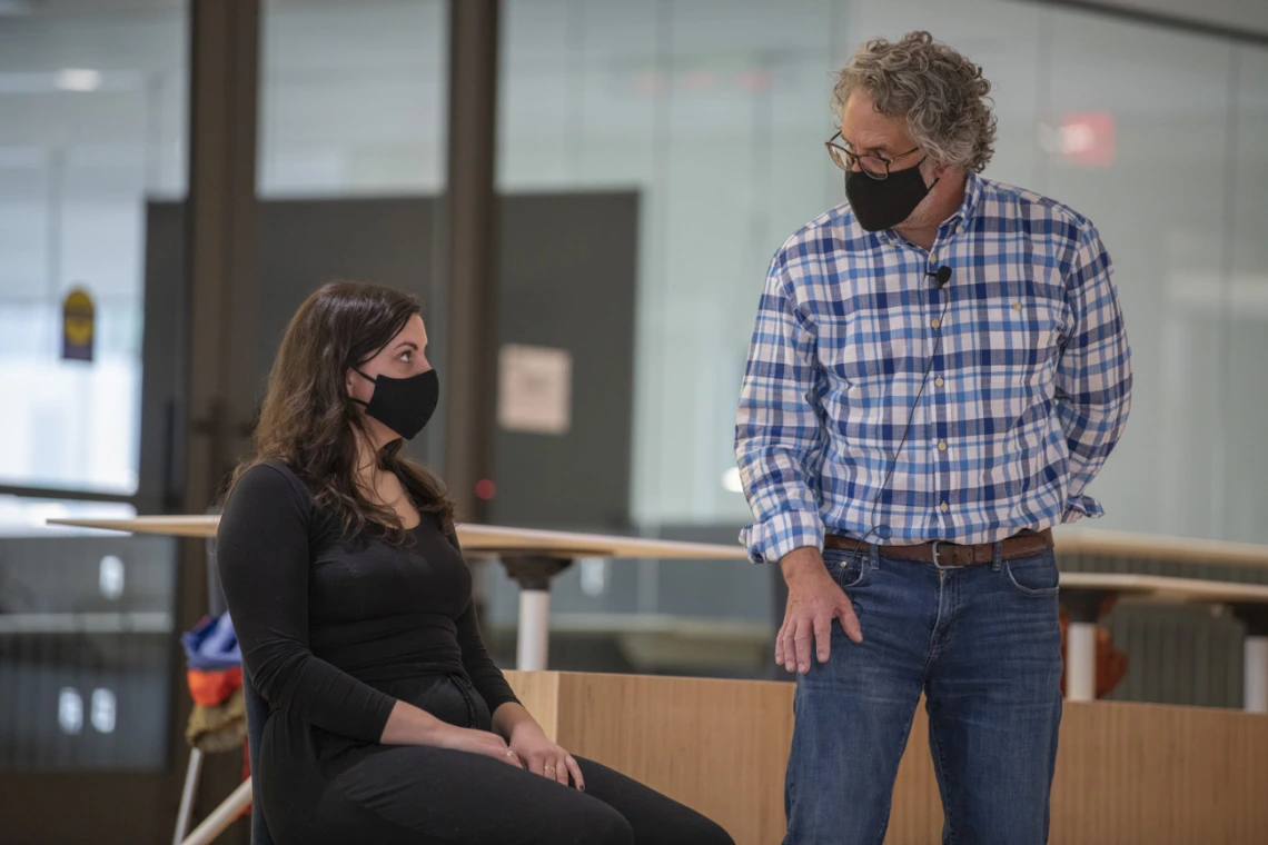 Jennie Greb listens as Andrew Belser explains how gravity pushes through her head down to her hips while in a seated position. Greb is one of the few in-person participants of the “Aging and the Arts” series inside the Forum in the Health Sciences Innovation Building.