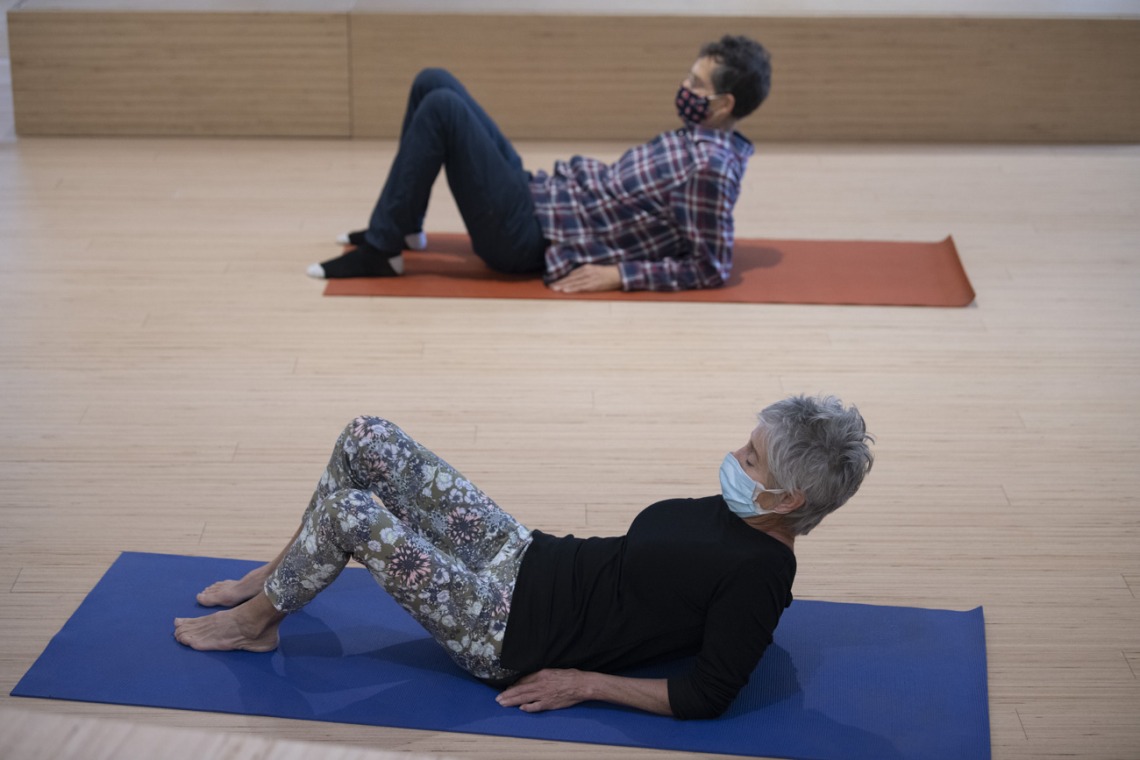 Ron Bachorski and Virginia Belser sit up while practicing a movement exercise.