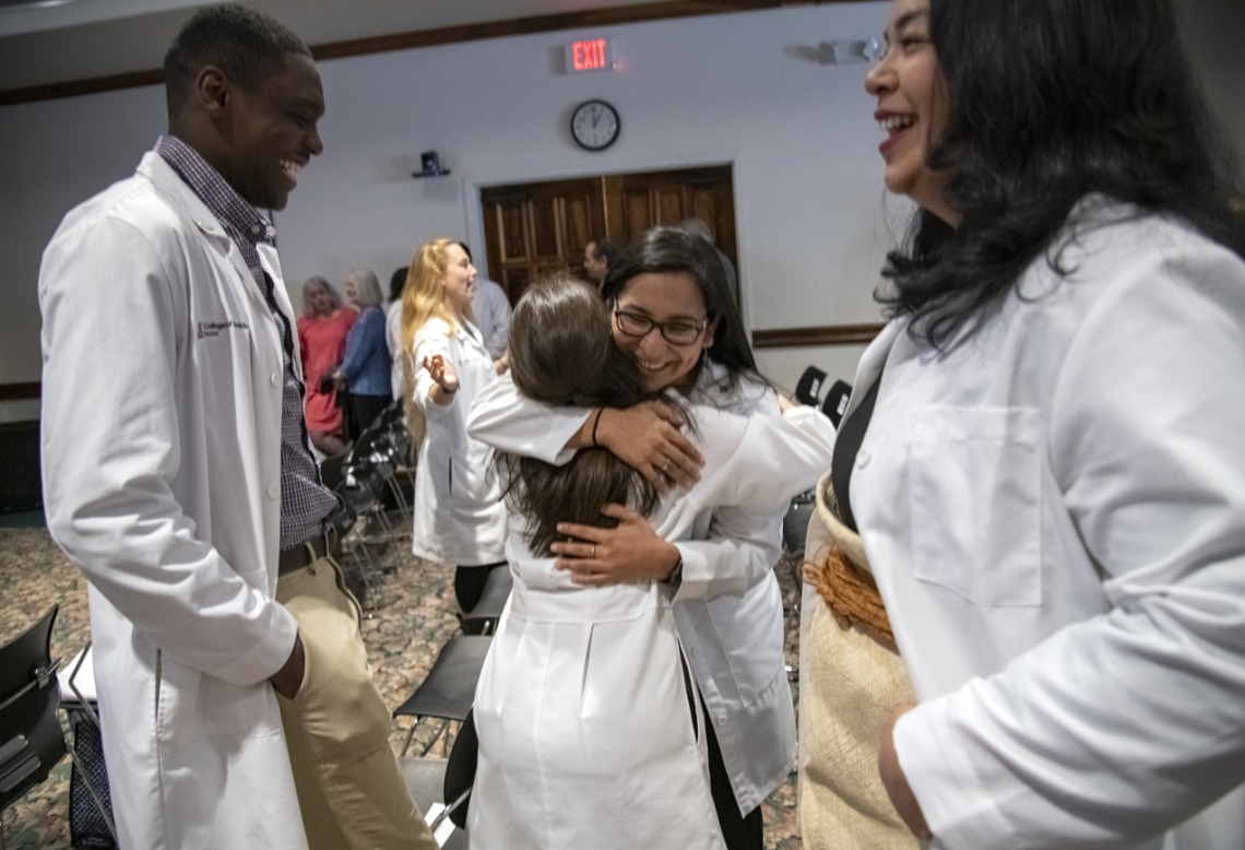 The first group of recipients of the Primary Care Physician scholarship program celebrated their awards at a reception in Tucson. These students – eight in Phoenix and 21 in Tucson, have committed to practicing a primary care profession in an underserved urban or rural community in Arizona. Here, Caylan Moore, left, and Kaloni Philipp, right, watch as Naiby Rodriguez, center, hugs China Rae Newman after the PCP Scholarship reception in Tucson, Ariz.