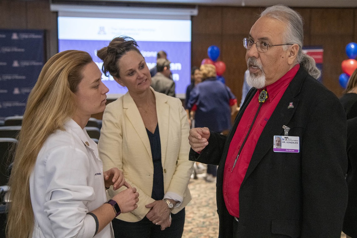 Dr. Carlos Gonzales speaks with Primary Care Physician scholarship recipient Hannah Shy, left, and her mother, center.