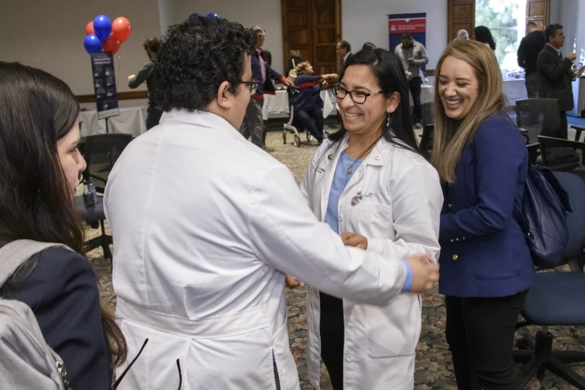 Primary Care Physician scholarship recipient Raymond Larez, MPH, congratulates Naiby Rodriguez at the Tucson scholarship reception. 